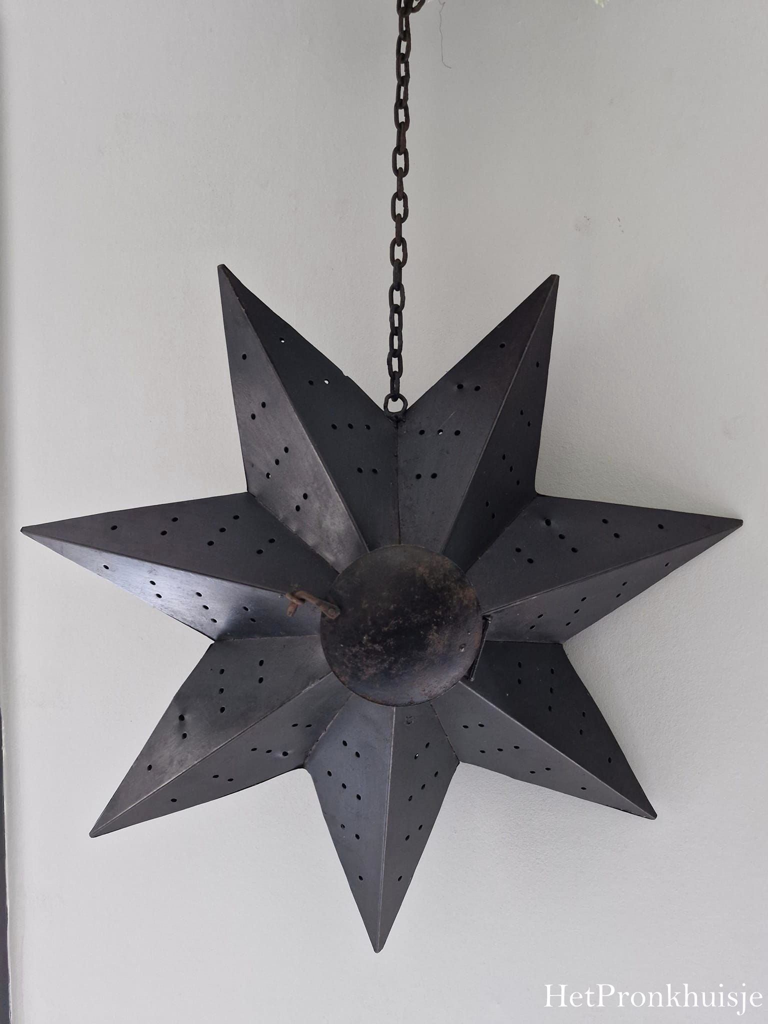 Roest metalen ster aan ketting. L